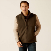 Man wearing a brown gilet over a beige shirt on a beige background
